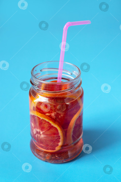 Скачать красно-апельсиновый лимонад в стеклянной банке с тенью на синем фоне фотосток Ozero