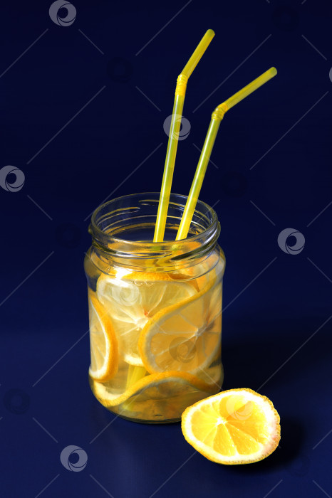 Скачать вода с ломтиками лимона в стеклянной банке на синем фоне фотосток Ozero