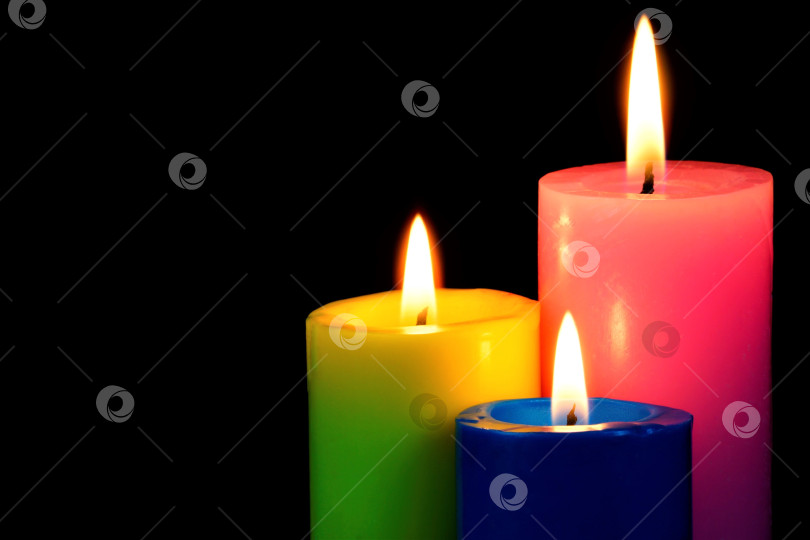 Скачать Яркие цветные свечи, горящие на черном креативном фоне. фотосток Ozero