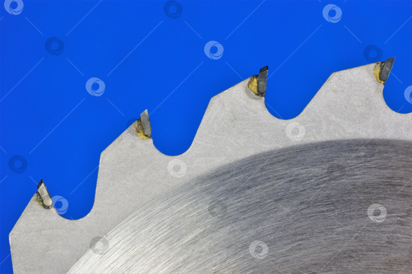 Скачать Зубья пильного полотна на синем фоне, крупным планом. фотосток Ozero