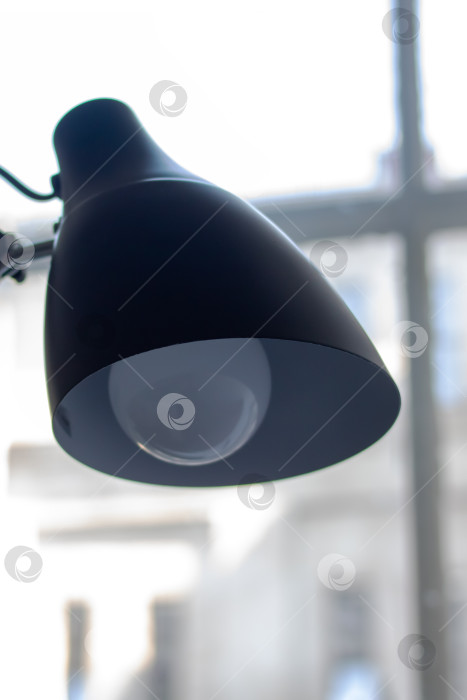 Скачать Черная настольная лампа на фоне окна крупным планом фотосток Ozero