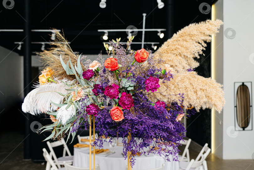 Скачать Красивый букет: Стол, украшенный обилием ярких цветов с перьями фотосток Ozero