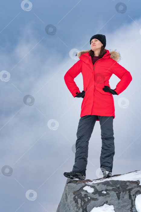 Скачать Женщина стоит на вершине скалистой горы на фоне неба с эффектными облаками. Концепция, копировальное пространство для индустрии туризма фотосток Ozero