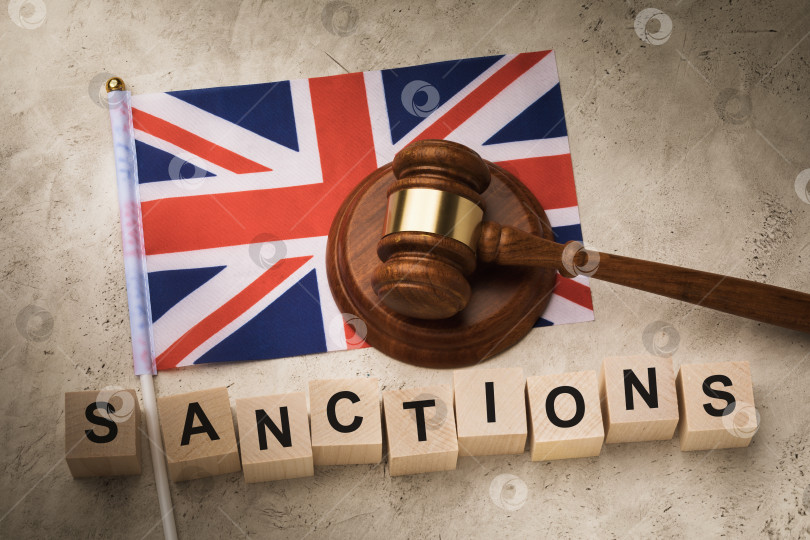 Скачать Флаг Англии, судейский молоток и деревянные кубики с текстом, концепция на тему британских санкций фотосток Ozero