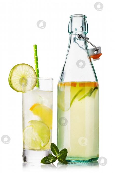 Скачать Вода с лимоном и лаймом в стакане и открытая бутылка, выделенные на белом фоне фотосток Ozero