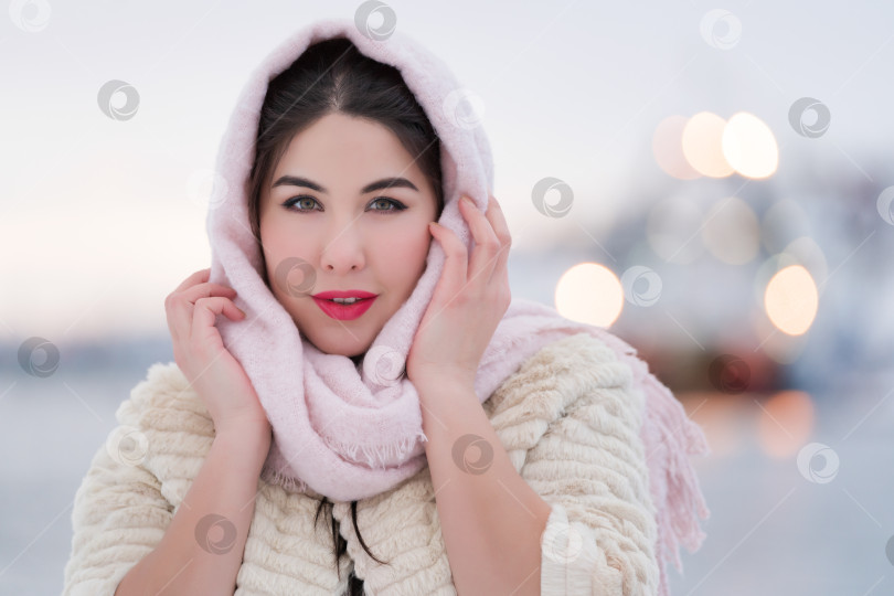 Скачать Зимний портрет счастливой молодой женщины-брюнетки зимним вечером на открытом воздухе. Мягкое освещение в вечернее время фотосток Ozero