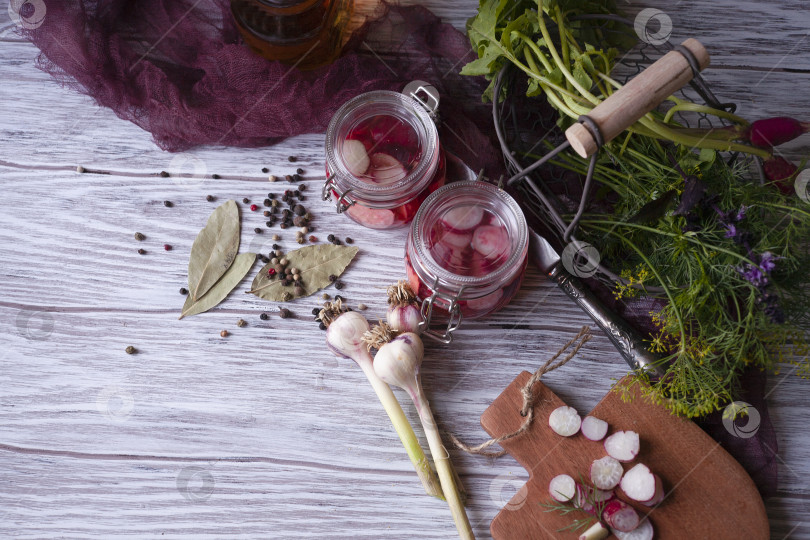 Скачать Две стеклянные банки с маринованной редькой с зеленью, чесноком и специями фотосток Ozero