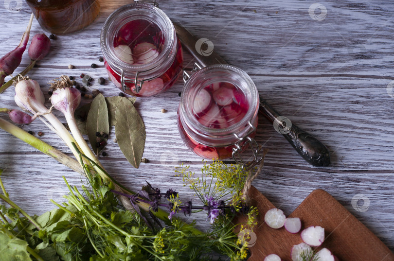 Скачать Две стеклянные банки с маринованной редькой с зеленью, чесноком и специями фотосток Ozero