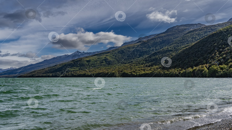 Скачать Прекрасное изумрудное озеро окружено горами. фотосток Ozero