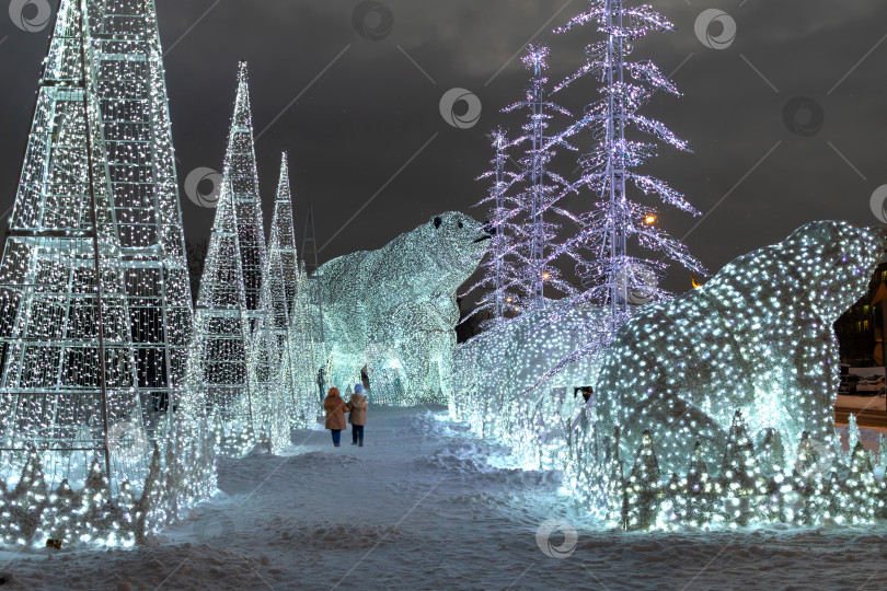 Скачать Световые инсталляции в виде рождественских елок и медведей. Праздничная иллюминация города ночью. Прогулка по снегу в сказочном зимнем лесу фотосток Ozero