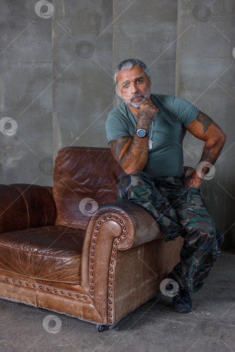 Скачать Солдат в камуфляже, солдат, сидящий в кресле.Зрелый мужчина-культурист в военной форме. фотосток Ozero