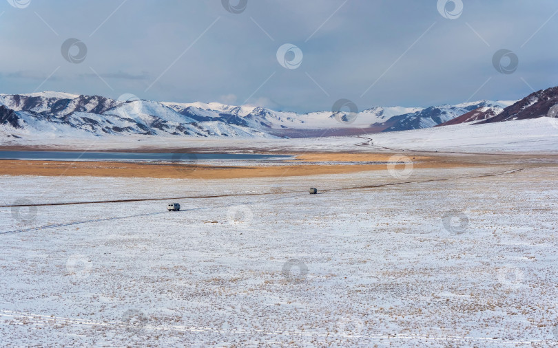 Скачать Широкая зимняя степь, узкая дорога, машины едут по плато по узкой грунтовой дороге. Широкая зимняя монгольская степь. фотосток Ozero