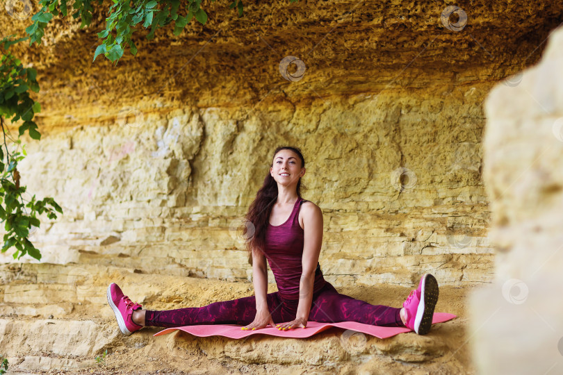 Скачать Девушка-спортсменка выполняет растяжку ног на свежем воздухе у стены. Концепция здорового образа жизни фотосток Ozero