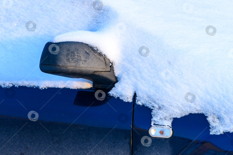 Скачать Черный автомобиль, занесенный снегом после метели и снегопада. Сугробы и замерзшие автомобили холодной зимой. фотосток Ozero
