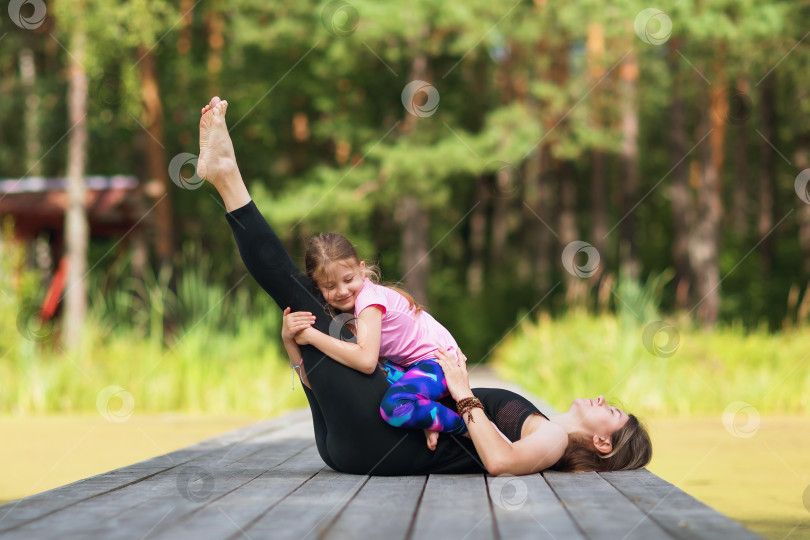 Скачать Мама и дочь отдыхают во время утренней зарядки на свежем воздухе фотосток Ozero