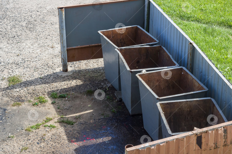 Скачать Старые металлические мусорные баки во дворе дома фотосток Ozero