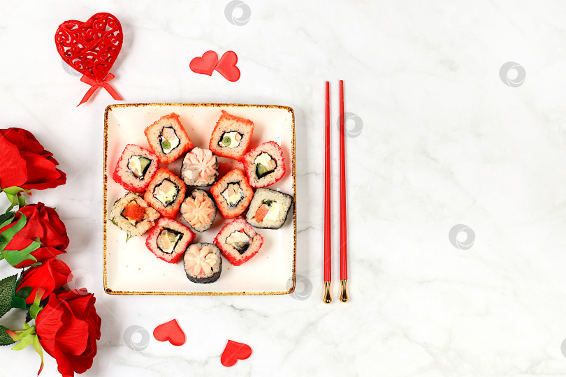 Скачать Угощение на День Святого Валентина, Сердце из свежих суши-роллов с розами, традиционная японская кухня, баннер для рекламы или пригласительного бара, меню, место для текста, вид сверху фотосток Ozero