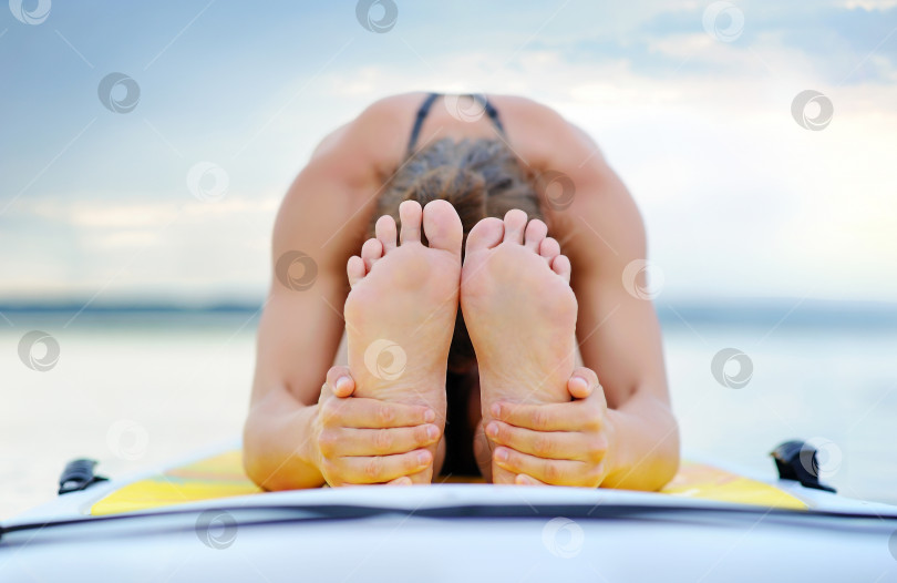 Скачать Женщина, держащаяся за ноги, лежа на суппорте фотосток Ozero