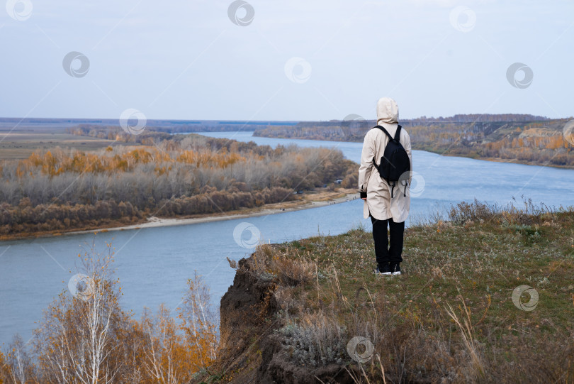 Скачать Женщина стоит на краю обрыва и смотрит на близлежащий остров, на море. Единение с природой. фотосток Ozero