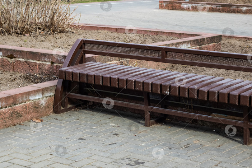 Скачать Коричневая деревянная скамейка в весеннем парке фотосток Ozero