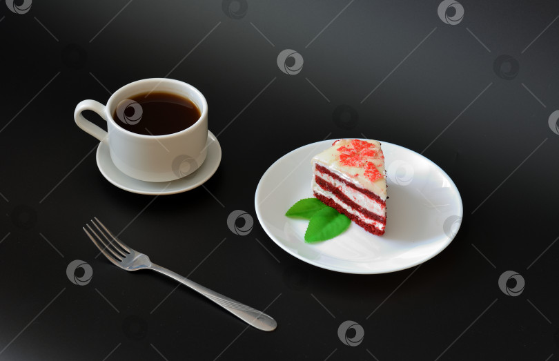 Скачать Чашка черного кофе на блюдце, вилка и миска с кусочком красного бархатного торта на черном фоне. фотосток Ozero