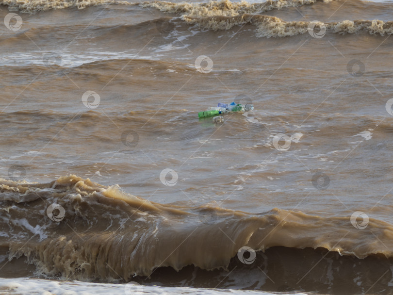 Скачать Пластиковые бутылки плавают на волнах в воде. Загрязнение океанской воды пластиковыми бутылками фотосток Ozero