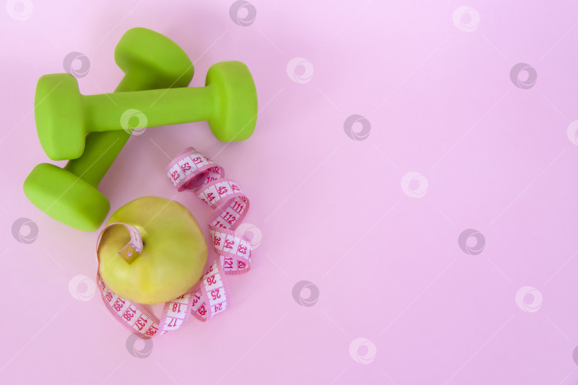 Скачать Зеленое яблоко и сантиметровая измерительная лента на розовом фоне. Спорт, спортивное питание, здоровое питание, диета. Пробел для текста. фотосток Ozero