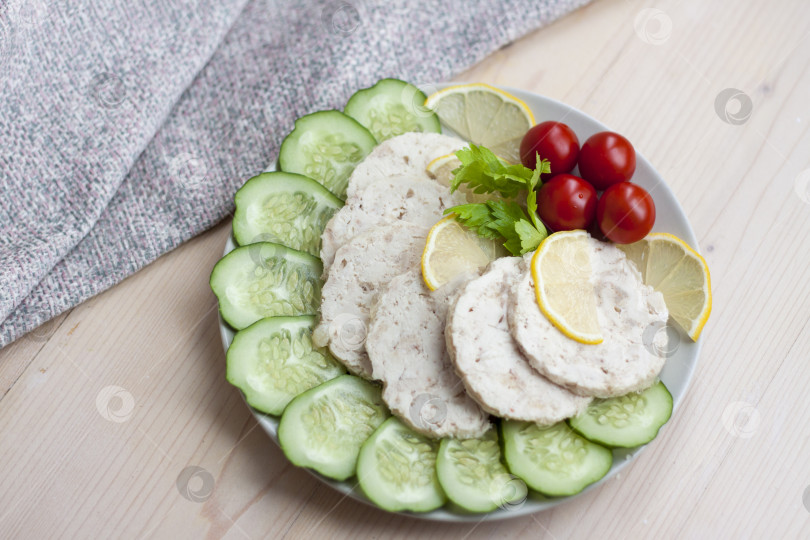 Скачать Мясо запеченной курицы нарезать ломтиками. Ломтики запеченного куриного мяса выкладывают на тарелку вместе с огурцом и помидорами черри. фотосток Ozero