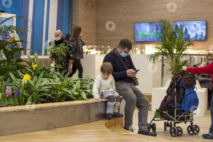 Скачать 2021-03-21 Москва, мужчина и дети отдыхают на парапете цветочной клумбы. Выставочный зал цветоводства в Москве на ВДНХ. фотосток Ozero