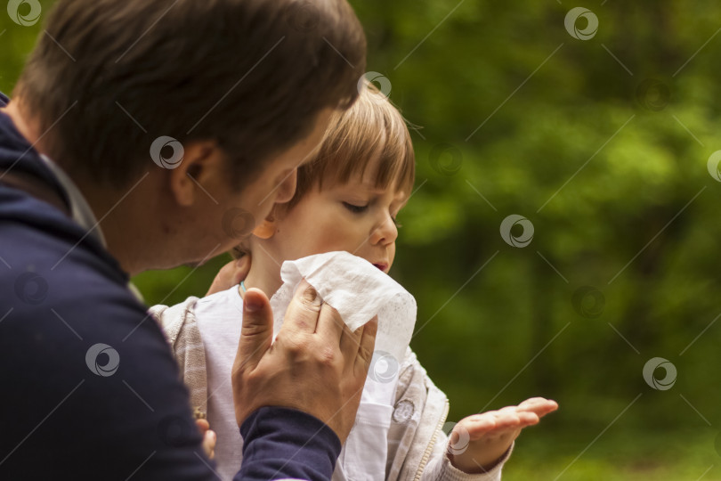 Скачать Отец заботится о своем маленьком сыне. Отец вытер лицо ребенка салфеткой. фотосток Ozero