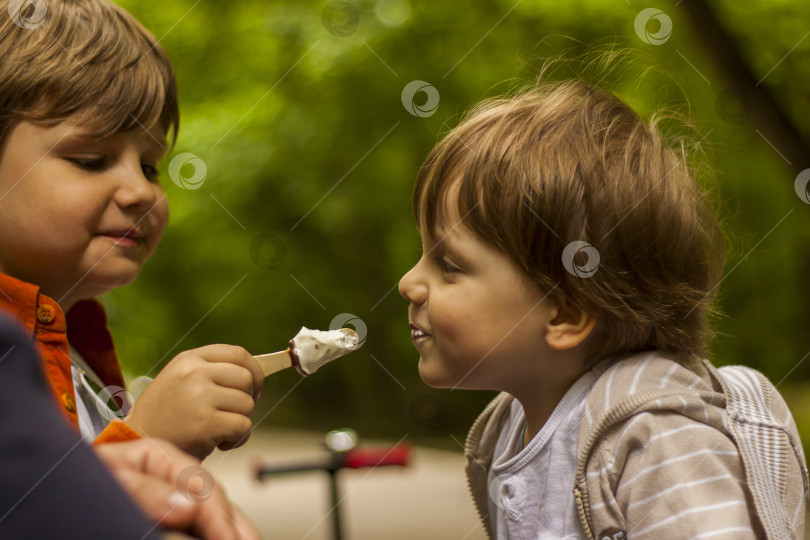 Скачать Дети весело проводят время в парке. Гуляйте, играйте и ешьте мороженое. фотосток Ozero