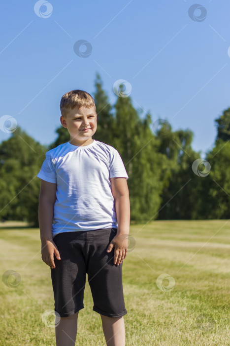 Скачать Жизнерадостный ребенок радостно улыбается. Я с удовольствием гуляю и играю на лужайке в теплую солнечную погоду в парке. эмоции детей на лице. фотосток Ozero