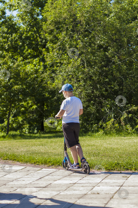 Скачать Мальчик-школьник едет на скутере. фотосток Ozero