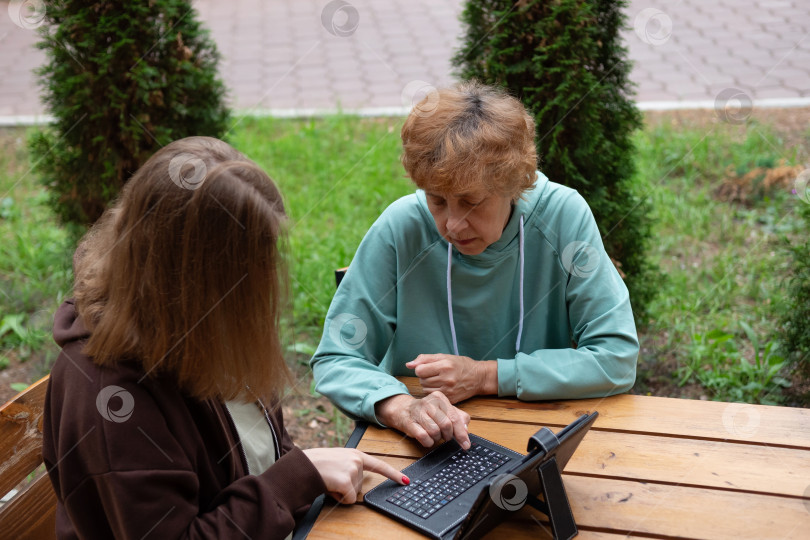 Скачать Внучка учит бабушку пользоваться планшетом. фотосток Ozero