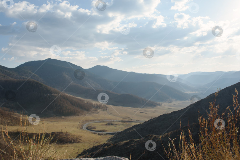 Скачать горный пейзаж с облачным небом и дорогой, проходящей через долину фотосток Ozero