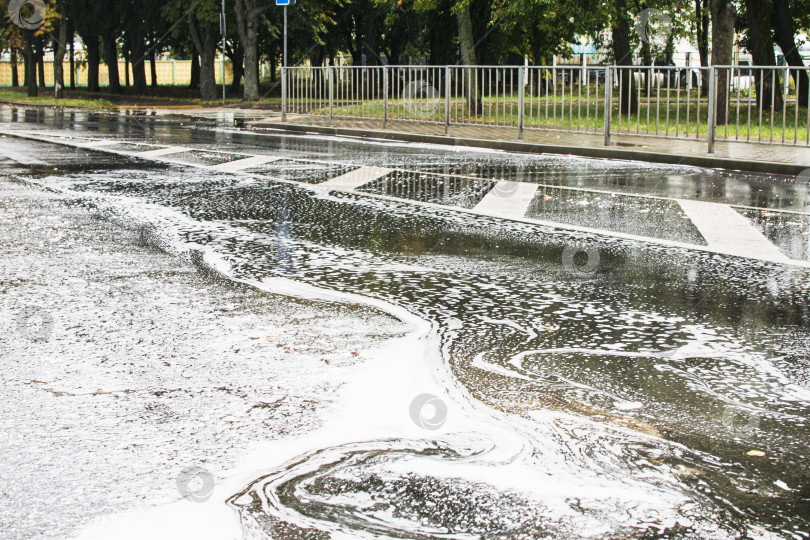 Скачать Вода с пеной течет по городской дороге фотосток Ozero