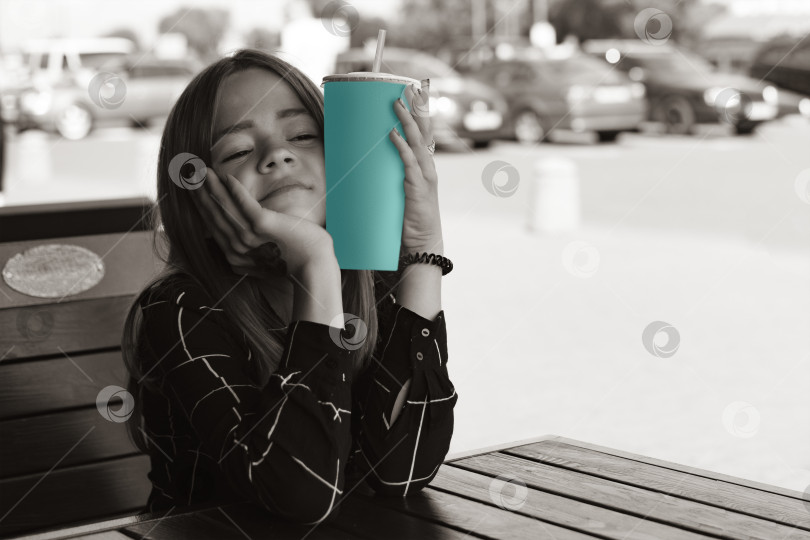 Скачать Молодая девушка сидит в кафе и пьет безалкогольный напиток фотосток Ozero