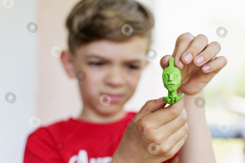 Скачать Маленький мальчик показывает поделку из пластилина фотосток Ozero