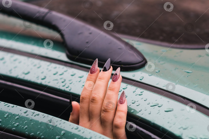 Скачать Женская рука с длинными ногтями высовывается из машины фотосток Ozero