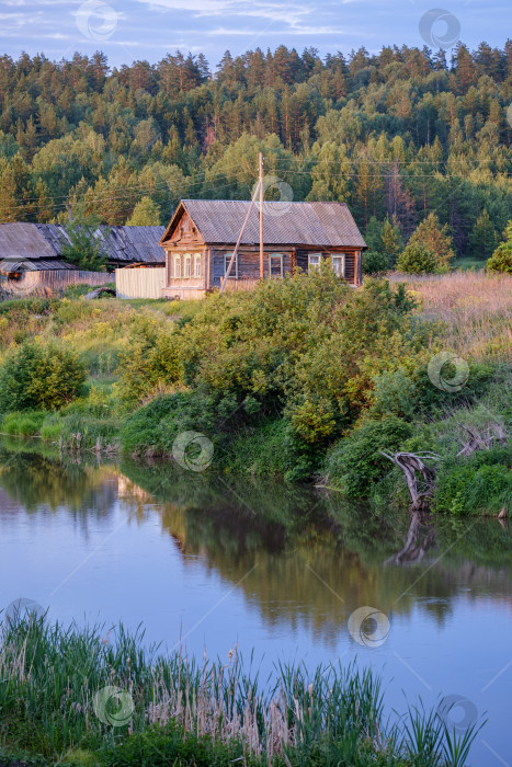Скачать река на переднем плане и старинный русский деревянный деревенский дом летним вечером на солнце фотосток Ozero