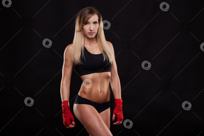 Скачать спортивная девушка позирует в красных повязках, изолированная на темном фоне боксерского бойца кикбоксера фотосток Ozero