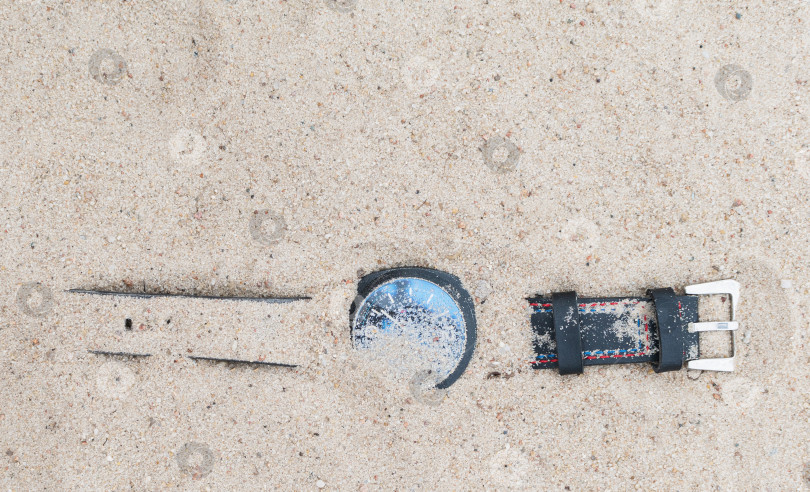 Скачать Наручные часы лежат на песке на пляже фотосток Ozero