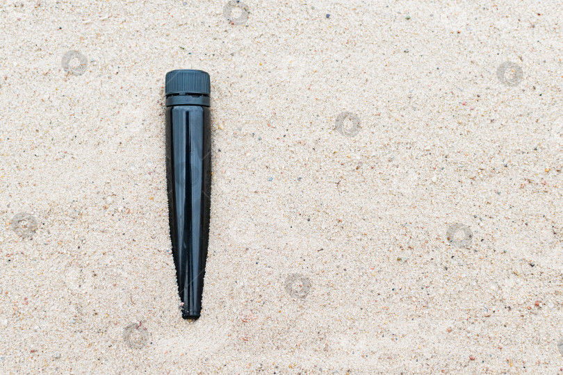 Скачать Маленькая пластиковая бутылка в песке на пляже фотосток Ozero