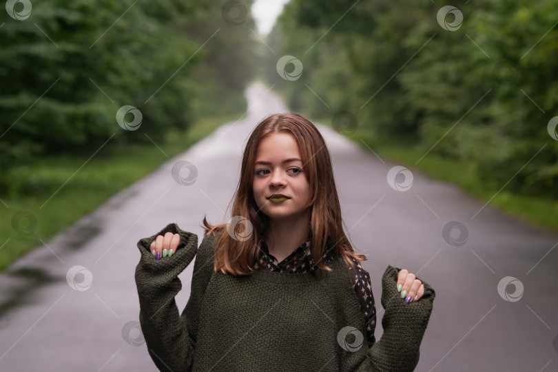 Скачать Молодая девушка идет по дороге в лесу фотосток Ozero
