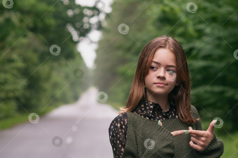 Скачать Молодая девушка идет по дороге в лесу фотосток Ozero