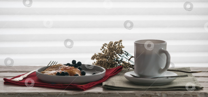 Скачать Чашка кофе и тарелка с блинчиками на декоративном столике фотосток Ozero