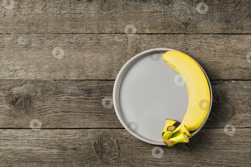 Скачать Легкая тарелка с бананом на декоративном фоне фотосток Ozero