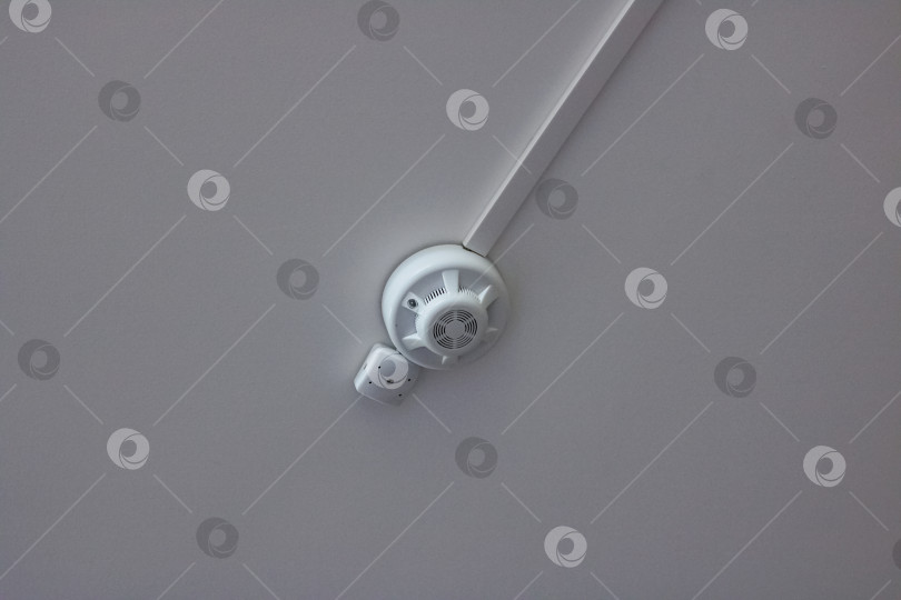 Скачать Белый пожарный извещатель на потолке крупным планом фотосток Ozero