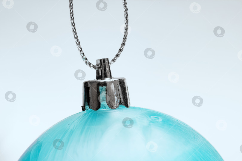 Скачать Синий рождественский шар на веревке на синем фоне фотосток Ozero