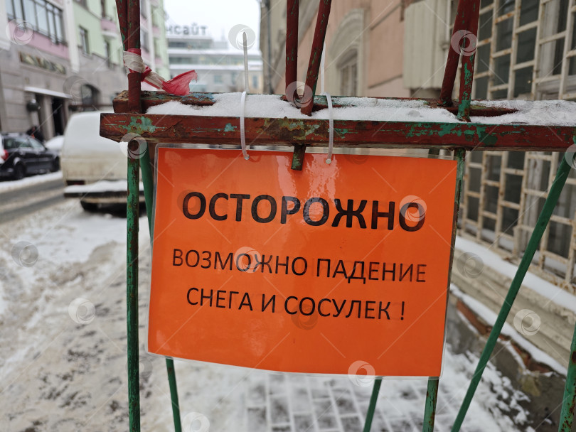 Скачать предупреждение о падении сосулек и снега на оранжевой бумаге около здания фотосток Ozero